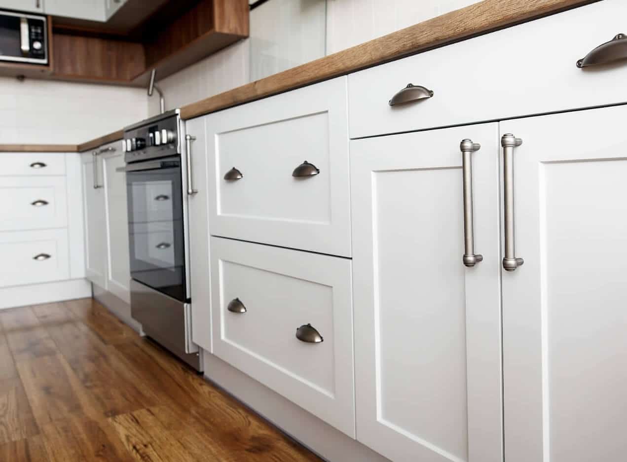 White kitchen cabinetry with modern, metallic looking handles