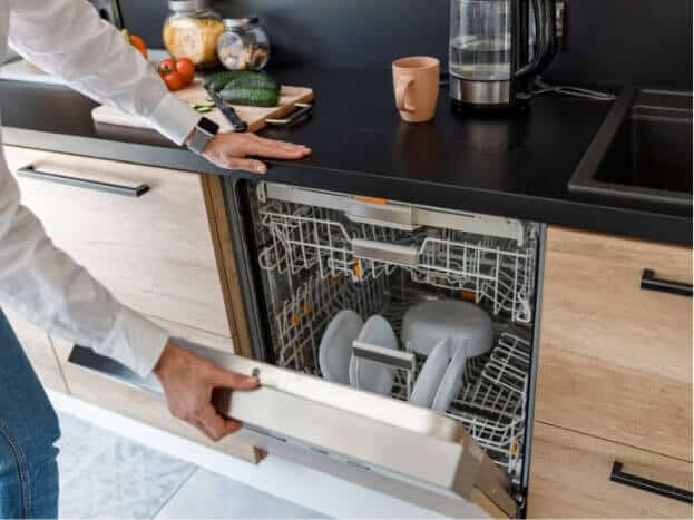 Man unloading a dishwasher with a few clean dishes