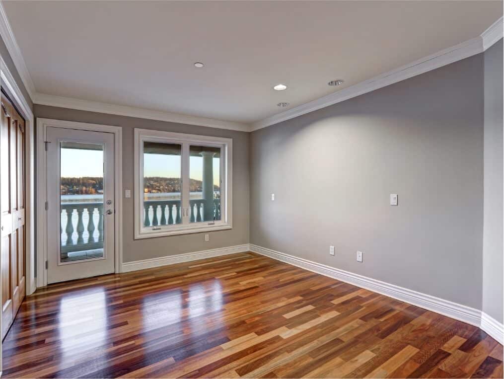 Spacious interior with hardwood flooring and a window overlooking a balcony