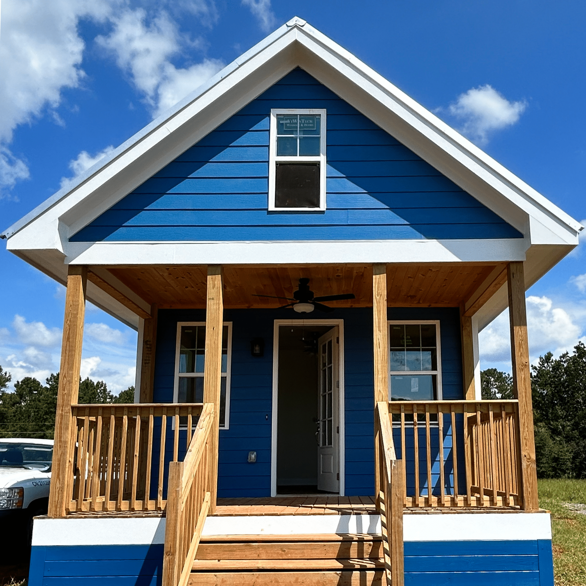 Brand new single cottage with blue exterior paneling and single staircase